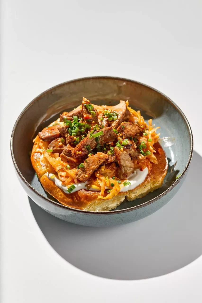 Шанежка с пряной отбивной, салатом из капусты и соусом из рассола.